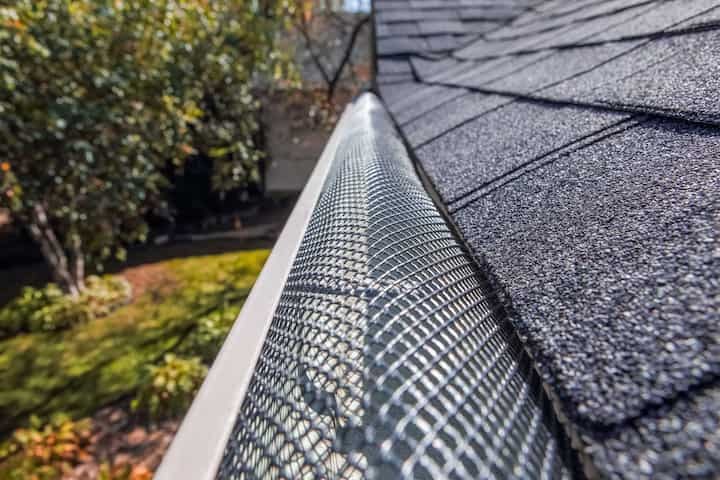 A contractor demonstrating the effectiveness of a gutter guard to a potential client in St. Petersburg